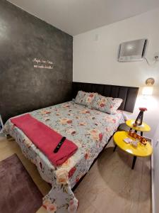 a bedroom with a bed and a yellow table at Studio Nosso Sonho in Cabo Frio