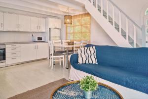 a living room with a blue couch and a kitchen at Villa Erato Periyali in Vasilikos