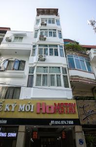 a tall white building with a sign in front of it at Khách sạn Thế Kỷ Mới in Hanoi