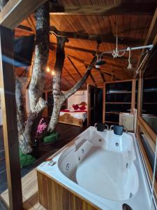 a bath tub in a room with a tree mural at Ecohotel Alflo Inn in Villeta +56 photos