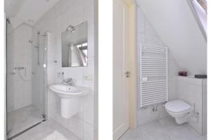 a white bathroom with a sink and a toilet at Augustinushof 13 in Vrouwenpolder +46 photos