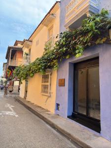 a building with ivy on the side of a street at Hotel Villa Alta Guest House in Cartagena de Indias