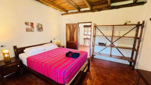 a bedroom with a bed with a red striped blanket at Paredon Surf House in El Paredón Buena Vista +42 photos