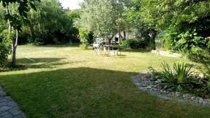 a garden with a table and chairs in the grass at Ferienwohnung am Bielersee in Erlach