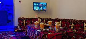 a living room with a couch with a table with cakes on it at MRHostel Luxor in Luxor