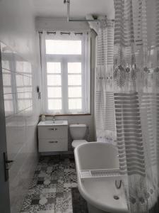a white bathroom with a tub and a toilet and a window at Spacious Luxury 2 bed appartment in Carcassonne +25 photos