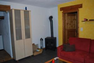 a living room with a red couch and a stove at Vire de Vie in Villiers