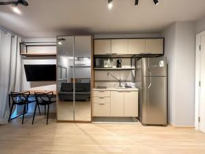 a kitchen with a stainless steel refrigerator and a table at Vila Mariana - Conforto e Praticidade in Sao Paulo