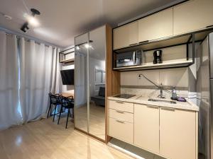 a kitchen with white cabinets and a dining room at Vila Mariana - Conforto e Praticidade in Sao Paulo