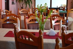 a dining room with a table with a red table cloth and chairs at Pensiunea Daniels in Văliug
