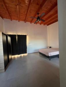 ein Schlafzimmer mit einem Bett und einem Deckenventilator in der Unterkunft La Victoria in San Luis