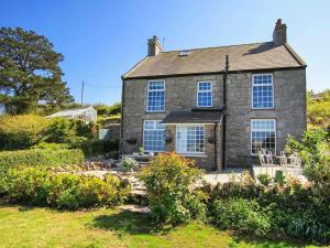an old stone house with a garden in front of it at Goleufryn in Beaumaris