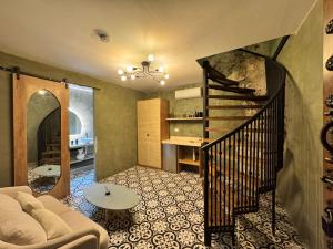 a living room with a couch and a spiral staircase at Hotel Villa Alta Guest House in Cartagena de Indias