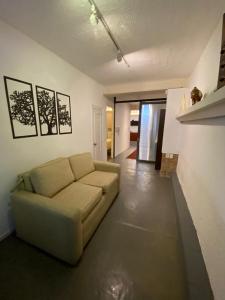 een woonkamer met een bank in een kamer bij Espacio Acevedo familiar in Montevideo