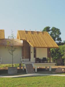 a small house with a bench and a roof at Pai Country Hut in Pai