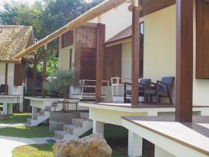 a house with a porch with chairs and a table at Pai Country Hut in Pai +43 photos