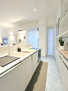 a white kitchen with a sink and a counter at Dimora Collection - Amalfi - Boutique Luxury Residence with direct sea view and access in Amalfi