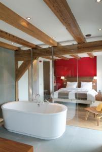 a bath tub in a room with a bedroom at Texel Suites in Oudeschild