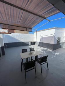 a table and chairs in a room with a ceiling at Casa La Peña - Playa y Naturaleza a un paso in La Redondela