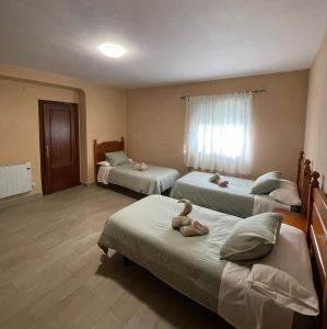 a room with three beds with stuffed animals on them at Casa La Peña - Playa y Naturaleza a un paso in La Redondela