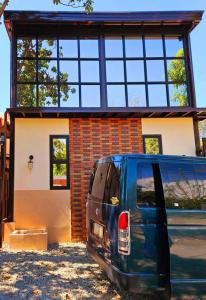 a blue van parked in front of a house at The Cozy Glass House by the Sea in Bauang
