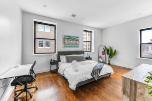 una camera da letto con un letto, una scrivania e finestre di 20 MIN to Manhattan! 2BR Luxurious Comfy & Spotless a Newark Altre 37 foto
