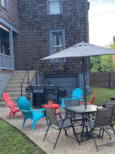a table and chairs with an umbrella and a grill at Charming Wheeling Island Home in Wheeling