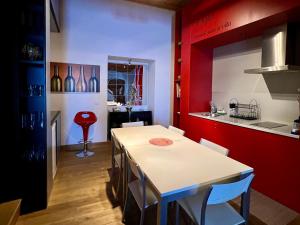 a kitchen with a white table and a red wall at Casa Rural Aracena Bliss in Aracena +9 photos