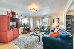 ein Wohnzimmer mit einem blauen Sofa und einem Fernseher in der Unterkunft Dtwn Escape half Mi to New Gore Mountain Lodge! in North Creek