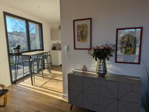 a living room with a vase of flowers on a dresser at Pré Madame, Terrasse, Parking in Riom