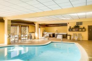 - une piscine dans une chambre d'hôtel avec des chaises et des tables dans l'établissement Snow Mountain Condo Hot Tub and Shuttle to Resort, à West Dover