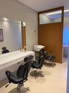 a salon room with chairs and a large mirror at Loft vista Mar - Entre Itajaí e Balneário Camboriú in Itajaí +19 photos