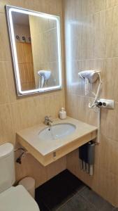 a bathroom with a sink and a mirror and a toilet at SNOW PARADISE GORBEA junto al Telecabina parking GRATIS in Sierra Nevada +19 photos