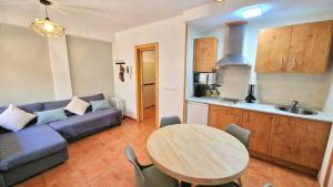 a living room with a table and a couch and a kitchen at SNOW PARADISE GORBEA junto al Telecabina parking GRATIS in Sierra Nevada
