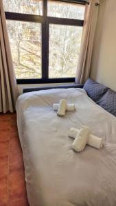 a white bed with two pillows on it with a window at SNOW PARADISE GORBEA junto al Telecabina parking GRATIS in Sierra Nevada