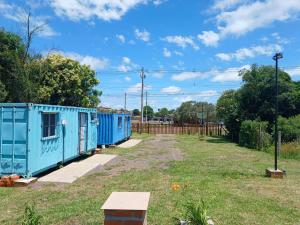 a row of blue train cars in a yard at Hospedagem Caminho do Parque in Vacaria +8 photos