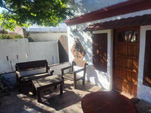 Un banco y una silla en un patio. en Flor de Lis Casa, en La Paloma