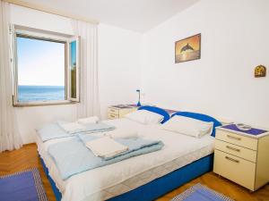 Schlafzimmer mit einem großen Bett und einem Fenster in der Unterkunft Apartments Adria in Petrovac na Moru
