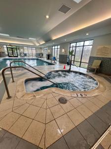 a swimming pool with a hot tub in a building at Hampton Inn & Suites Stroudsburg Bartonsville Poconos in Stroudsburg