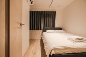 a small bedroom with a bed and a window at Apb 两国 in Tokyo