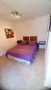 a bedroom with a large purple bed in a room at Descanso en la Patagonia in Trelew