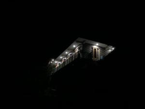 a building with lights on the side of it at night at Tirthan Life Homestay in Kulu
