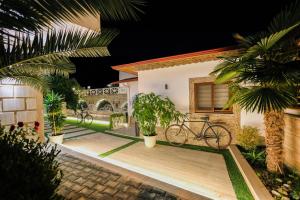 a house with a bike parked on a wooden deck at Hotel Mimani in Berat