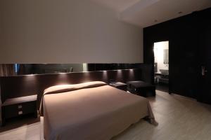 a bedroom with a bed and a wooden wall at Muà Boutique Bologna in Bologna