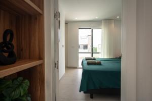 ein Schlafzimmer mit einem grünen Bett und einem Fenster in der Unterkunft Almendro Villa 2V12 with heated pool at Santa Rosalia Resort in Torre-Pacheco + 18 Fotos