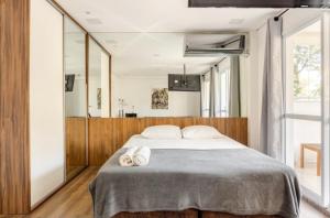 a bedroom with a large bed with two towels on it at Confortável Loft em Santo Amaro -Alto da Boa Vista in Sao Paulo +12 photos