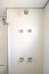 a bathroom with a shower with white tiles at Confortável Loft em Santo Amaro -Alto da Boa Vista in Sao Paulo