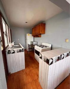a kitchen with white appliances and wooden floors at Habitación doble CAPU in San Felipe Hueyotlipan