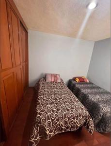 a bedroom with two beds and a door at Habitación doble CAPU in San Felipe Hueyotlipan