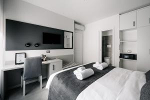 una camera da letto in bianco e nero con letto e scrivania di B&B LUMAS a Roma